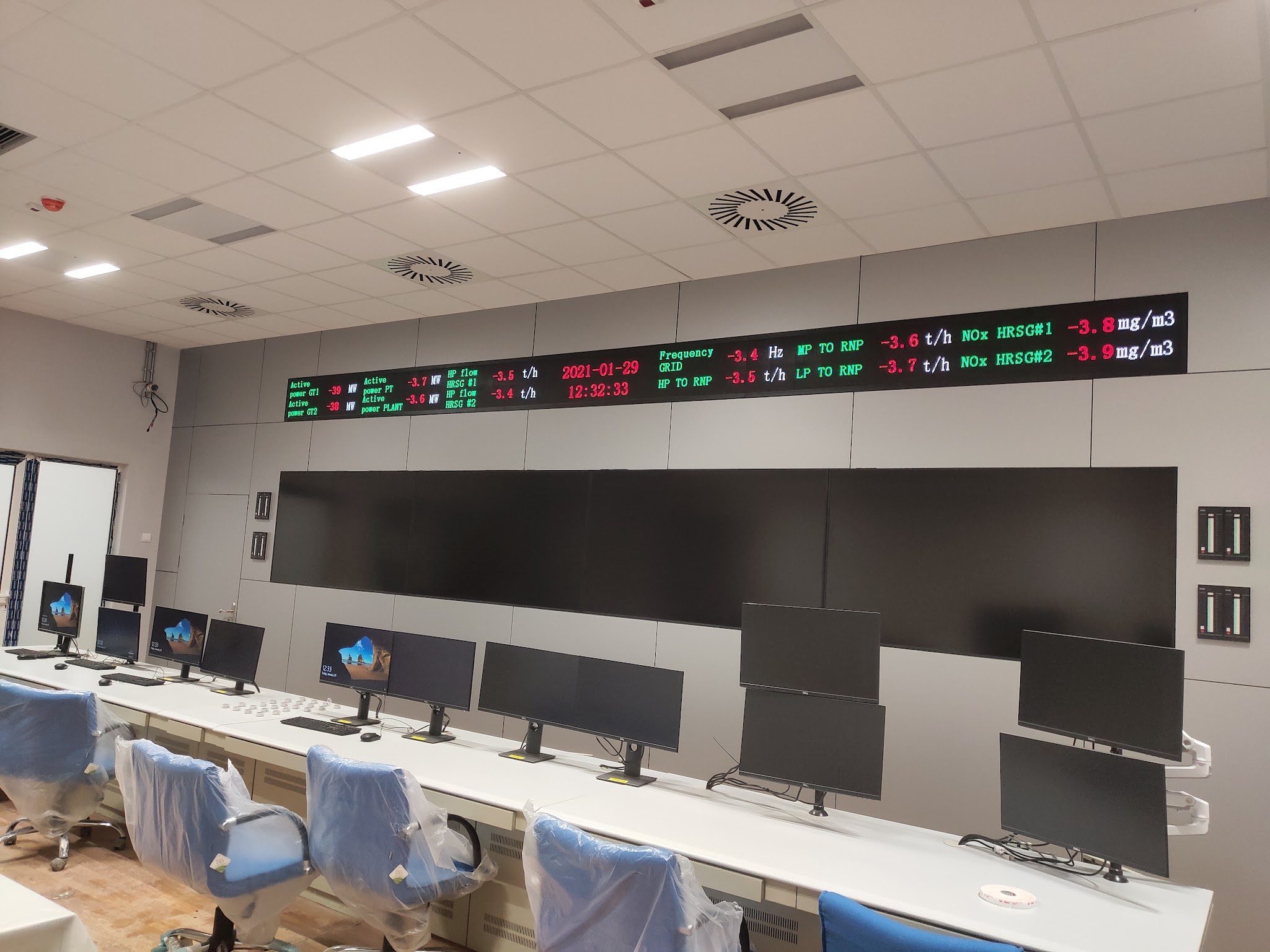 Combined-cycle plant control room with operator consoles and overview display